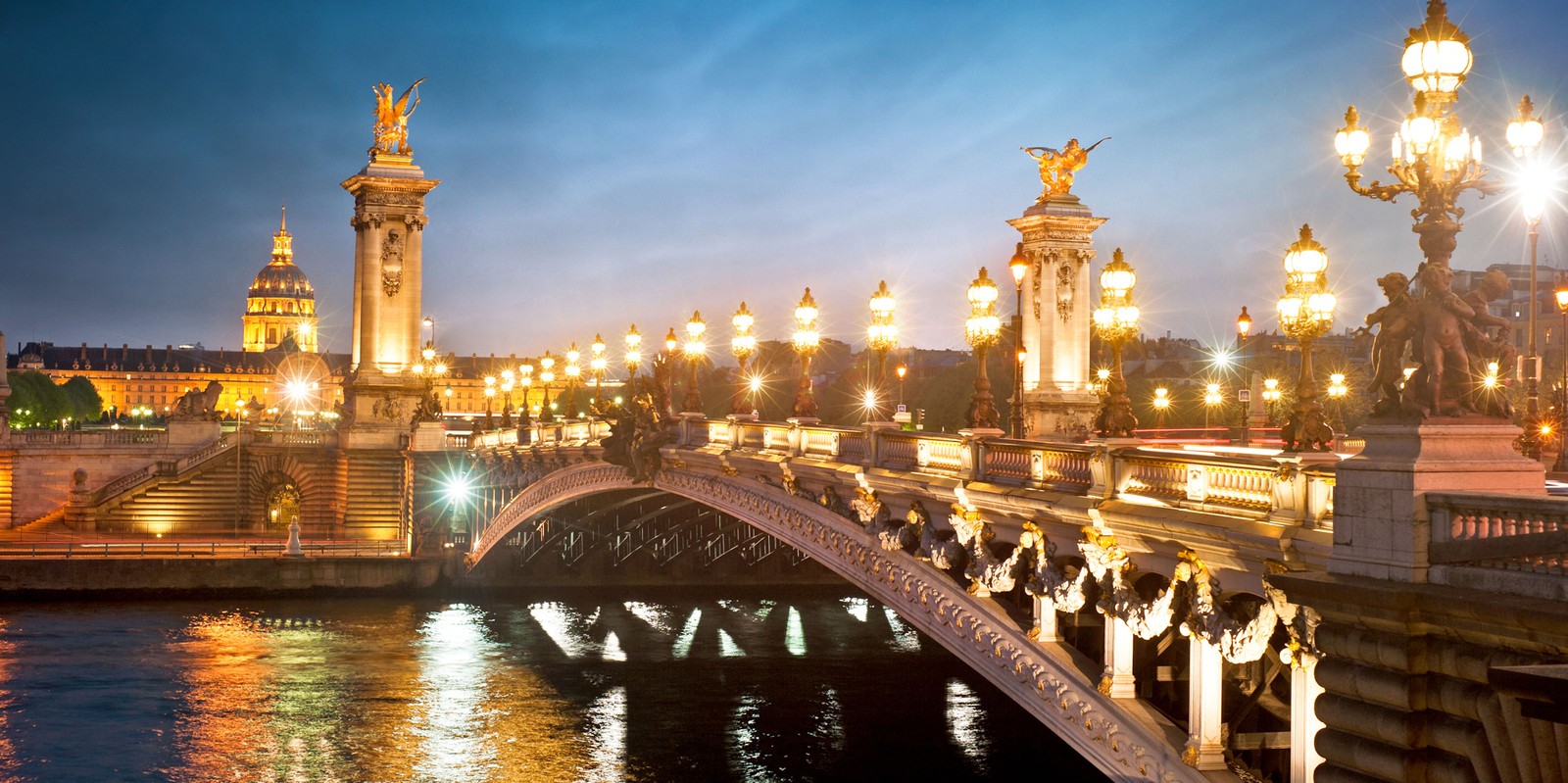 Une vue aérienne d'un pont sur la rivière avec des lumières allumées la nuit (tour eiffel, pont alexandre iii, seine, point de repère, ville)