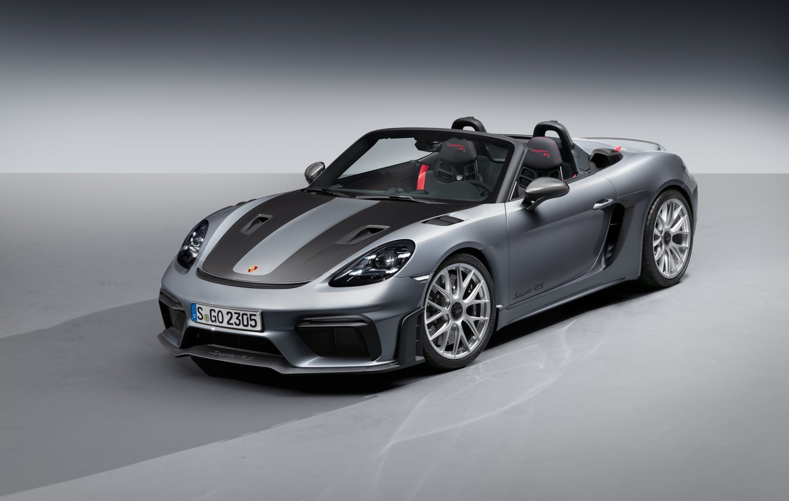 Un porsche deportivo plateado con techo negro y asientos rojos (porsche 718 spyder rs, coches deportivos, convertible, supercoche, roadster)