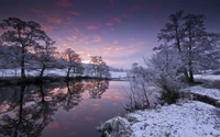 Coucher de soleil d'hiver serein reflété dans un paysage enneigé