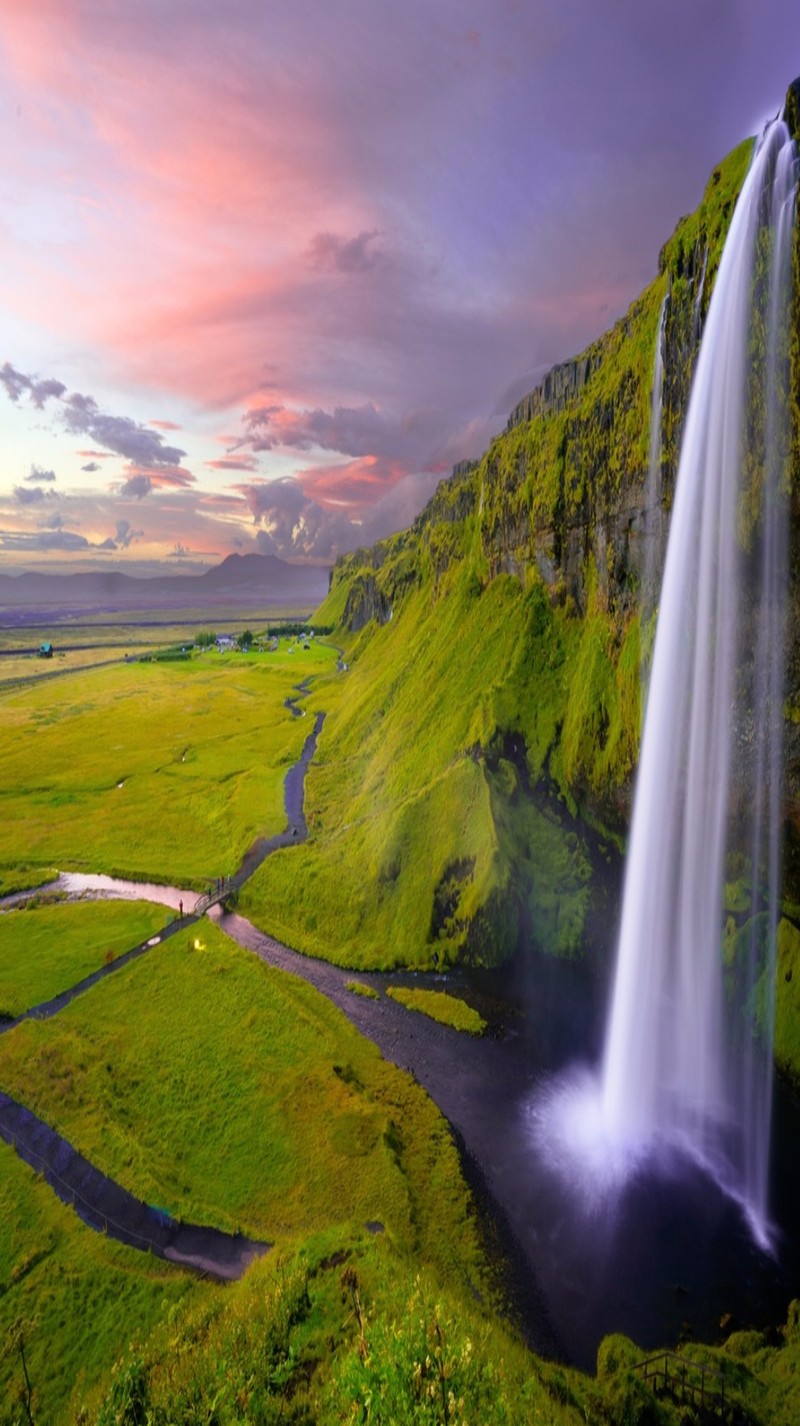 Cascada en medio de un valle verde con un cielo rosa (paisaje, foto, agua)