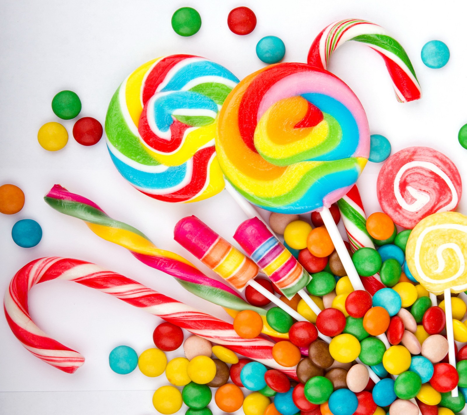 A close up of a pile of candy and candies on a white surface (candy, colorful, sweet)