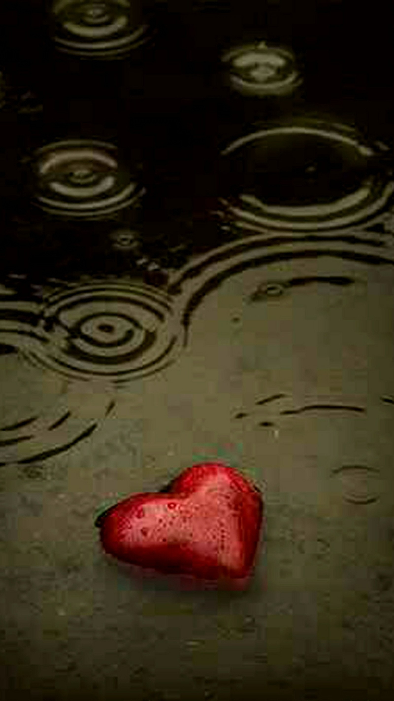 Arafed heart shaped object in the middle of a puddle of water (a rain, broken, dark, heart, red)