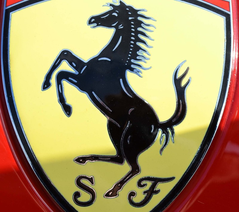 Крупный план логотипа ferrari на красном автомобиле (машина)