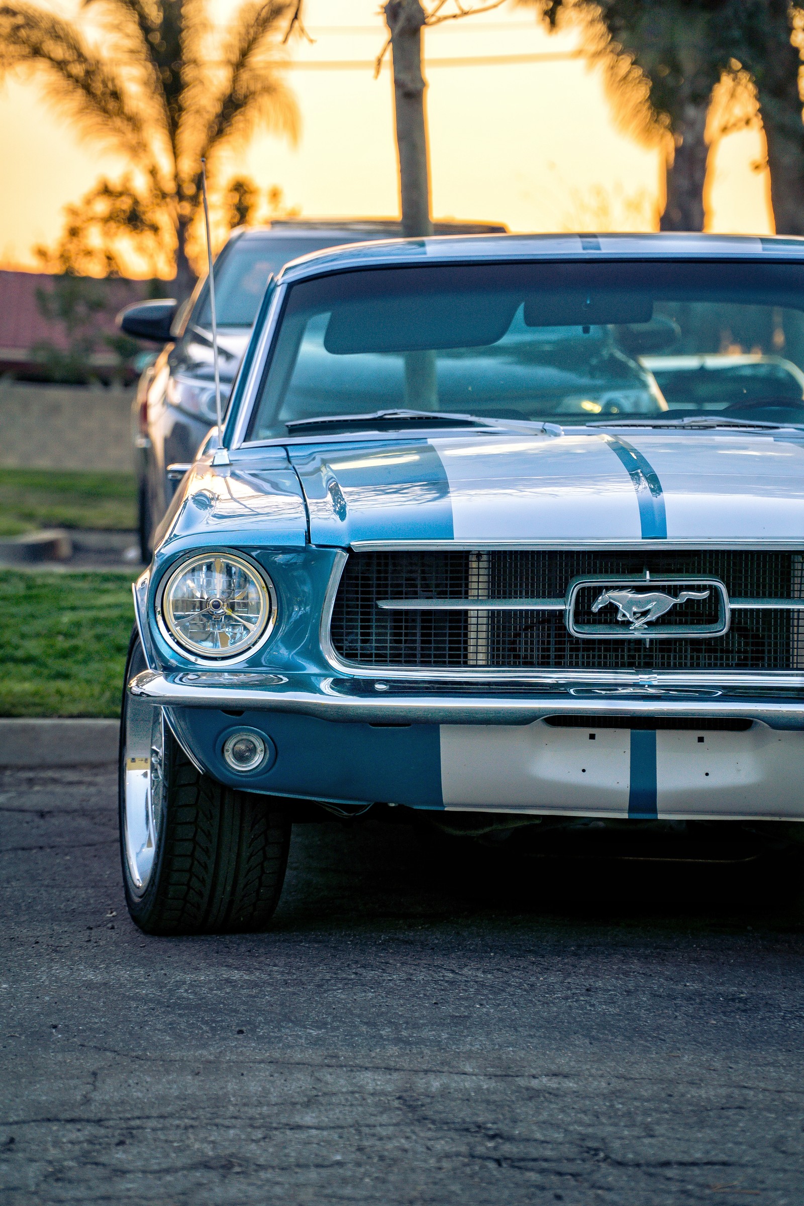 Un mustang azul y blanco estacionado en un aparcamiento (estadounidense, coche, coches, cargador, dodge)