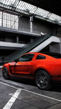 Ford Mustang rojo en un entorno industrial con arquitectura impactante.