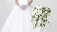 Elegance in White: A Bride's Floral Bouquet and Gown