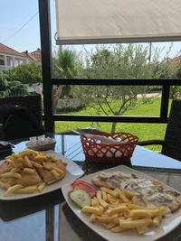 Delicioso brunch con papas fritas e ingredientes frescos en un entorno al aire libre pintoresco