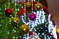 Los vibrantes adornos navideños brillan contra un fondo de luces centelleantes, capturando el espíritu festivo de la temporada navideña.