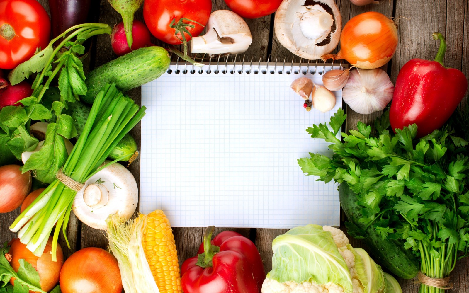 Un primer plano de un cuaderno rodeado de verduras (alimentos naturales, verdura, comida, comida vegetariana, comida local)