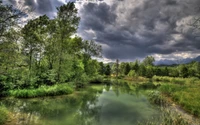 Selvática exuberante reflejada en aguas serenas bajo cielos dramáticos