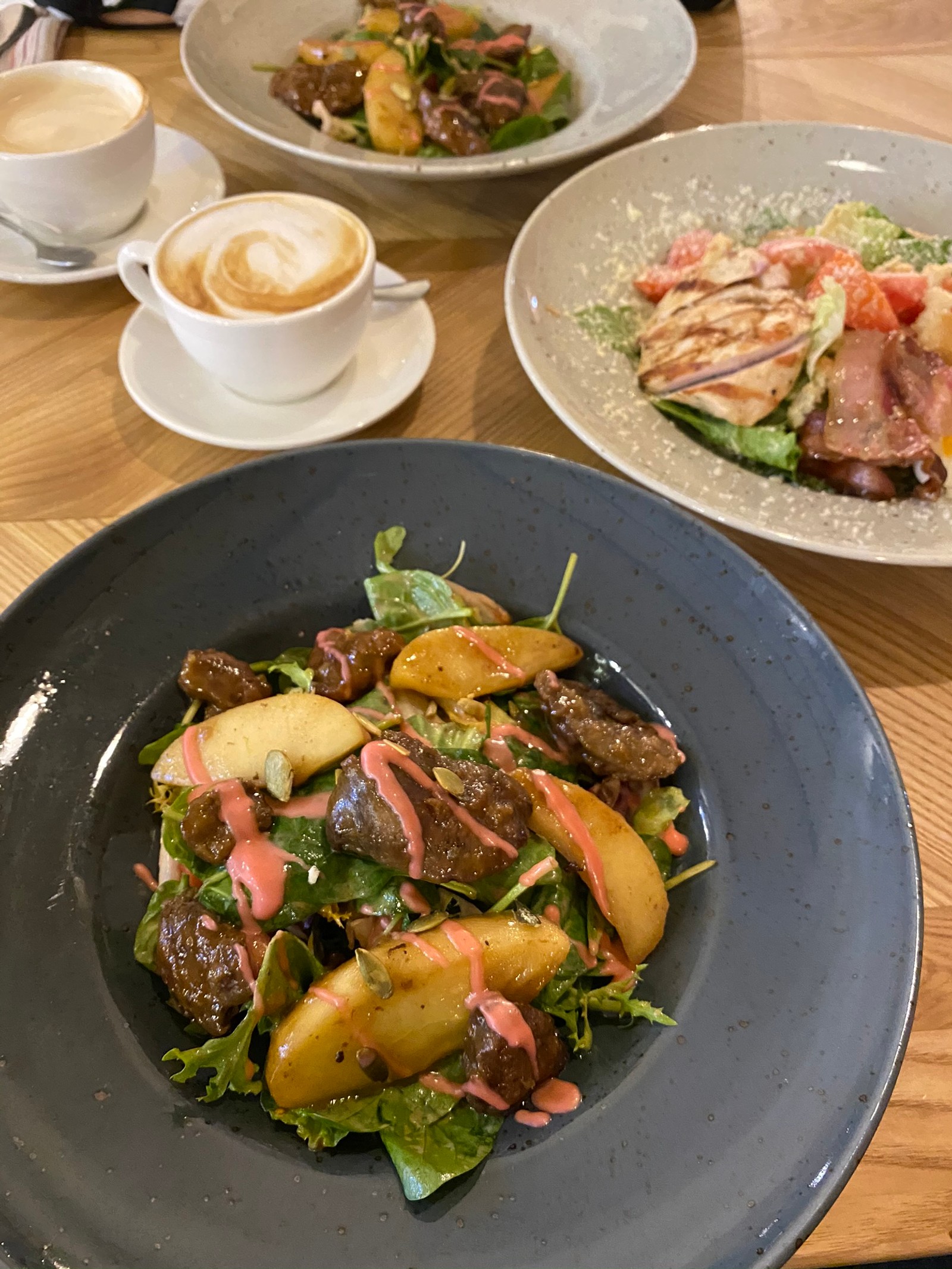 Hay dos platos de comida en una mesa con una taza de café (comida, cocina vegetariana, cocina tailandesa, ensalada, almuerzo)