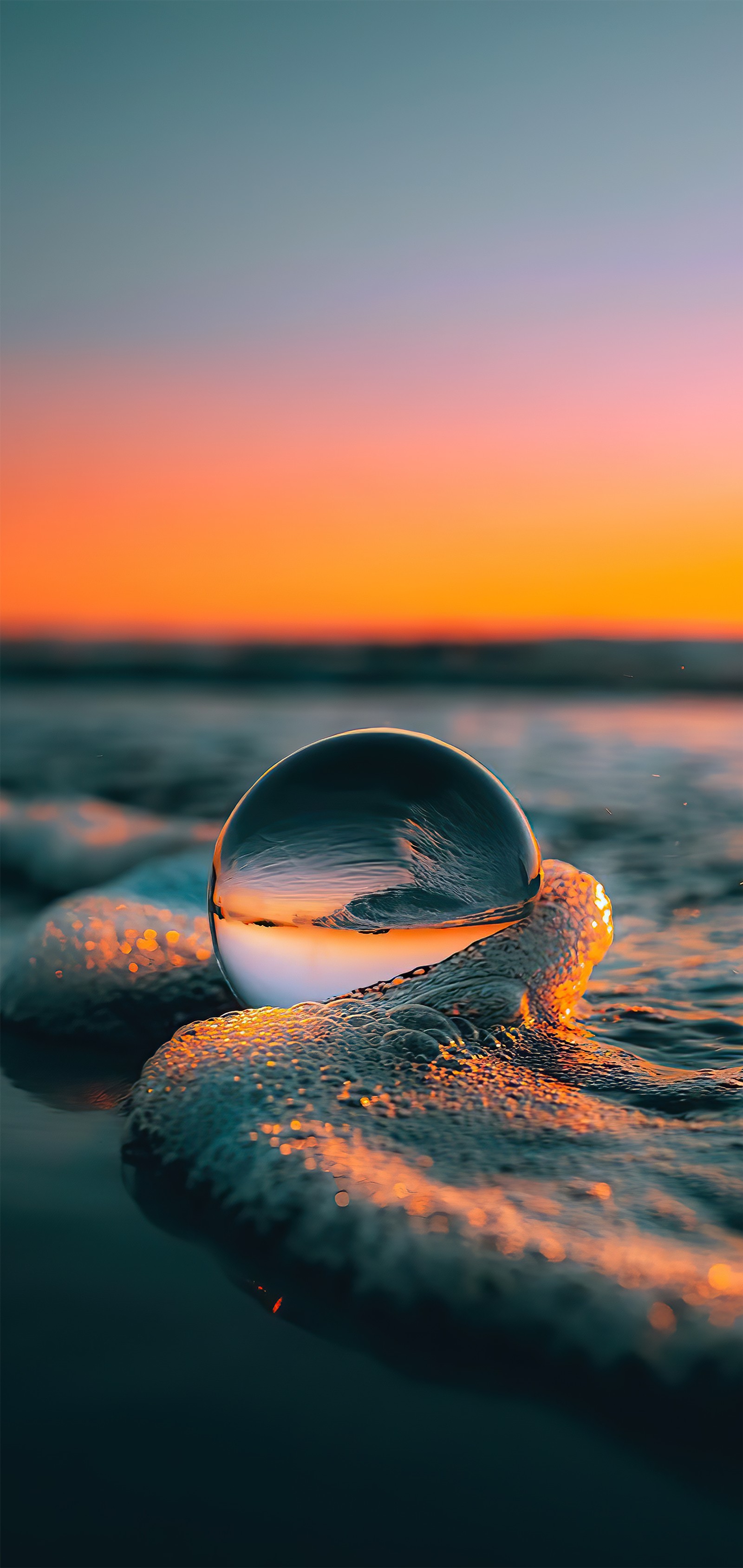 Um close em uma bola de vidro na praia perto do oceano (água, smartphone, nuvem, atmosfera, líquido)