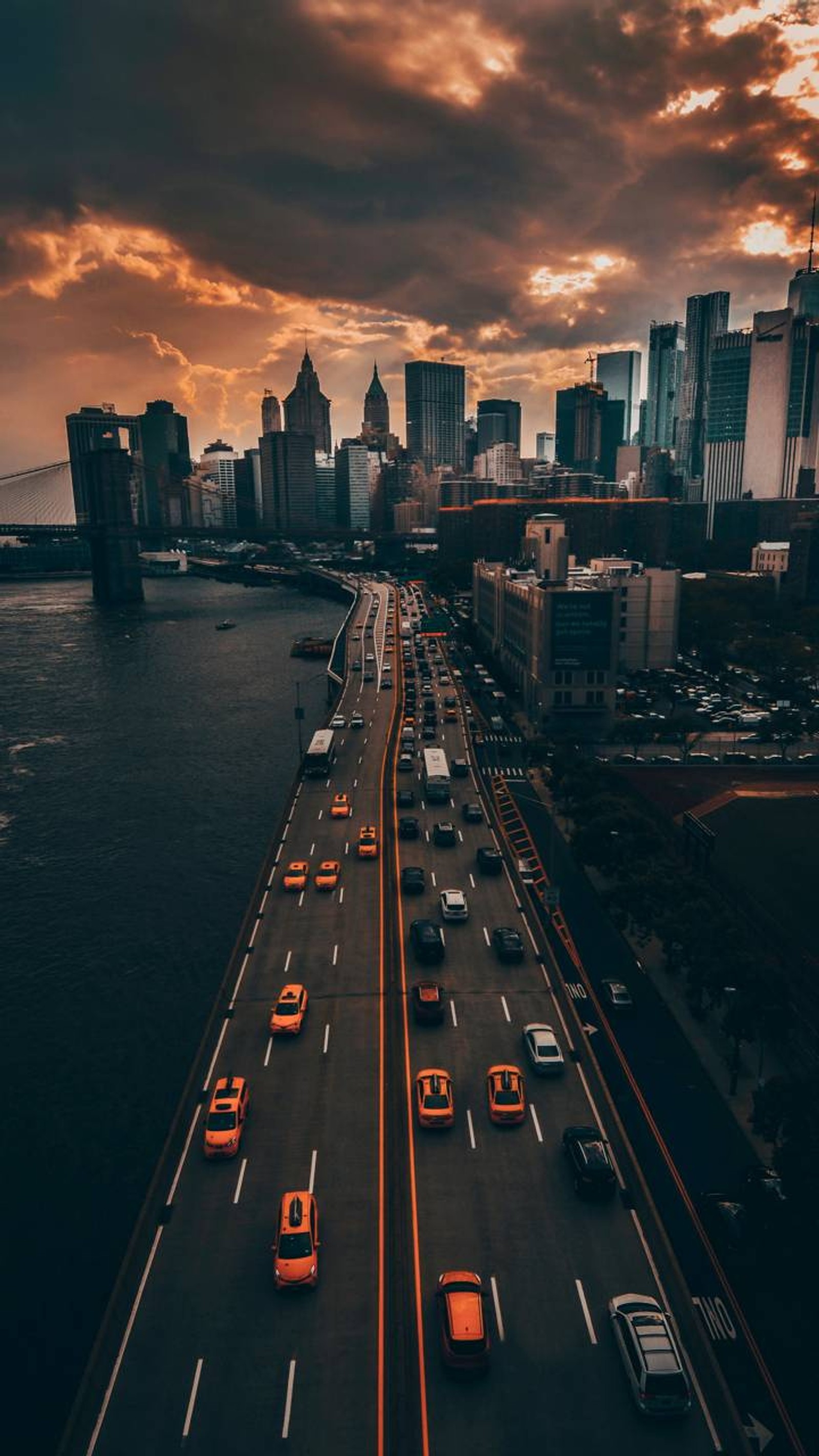 Uma vista de uma rodovia com carros dirigindo e uma cidade ao fundo (cidade, nova york, new york)