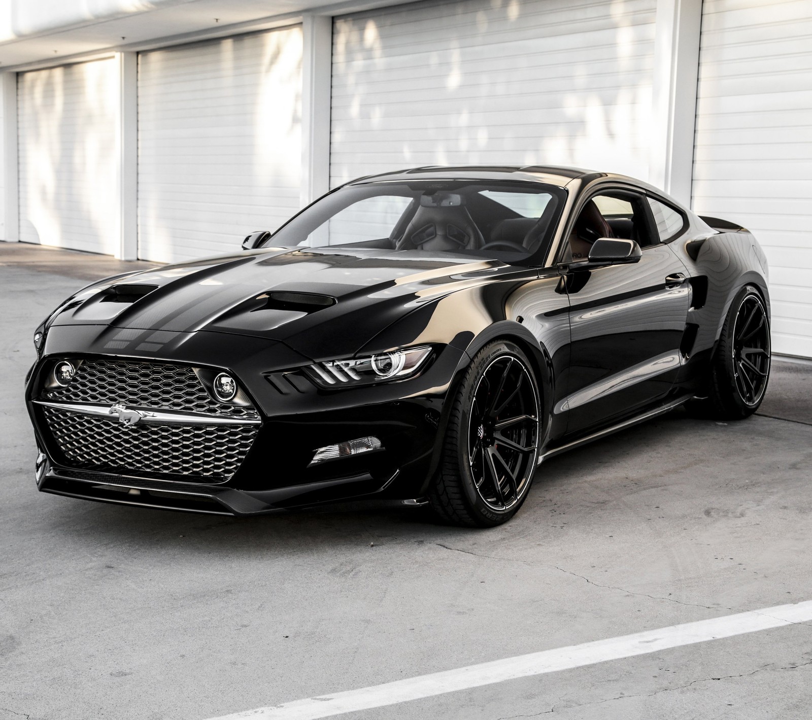 Un primer plano de un mustang negro estacionado en un aparcamiento (américa, coche, negro, ford, mustang)