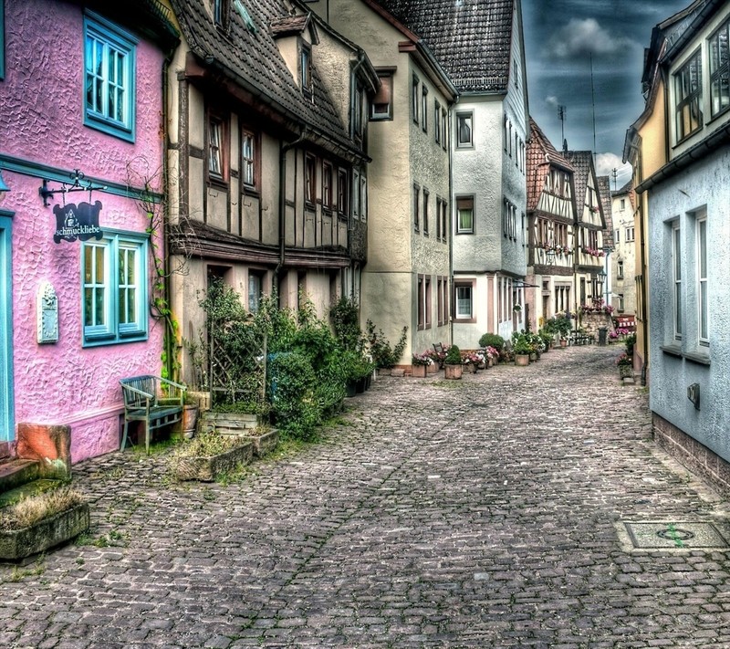 There is a cobblestone street with a few houses on it (city, nice view)