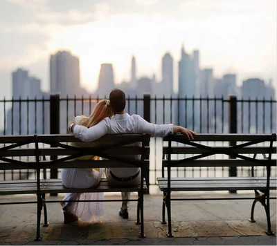 Étreinte romantique au coucher du soleil : un couple mignon surplombant la ville