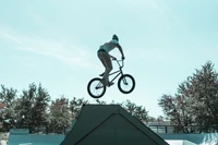 Ciclista de BMX realizando uma manobra no ar em um skatepark