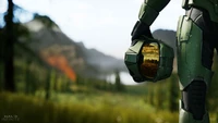 Mestre Chefe segurando seu capacete em meio a uma paisagem exuberante em Halo Infinite