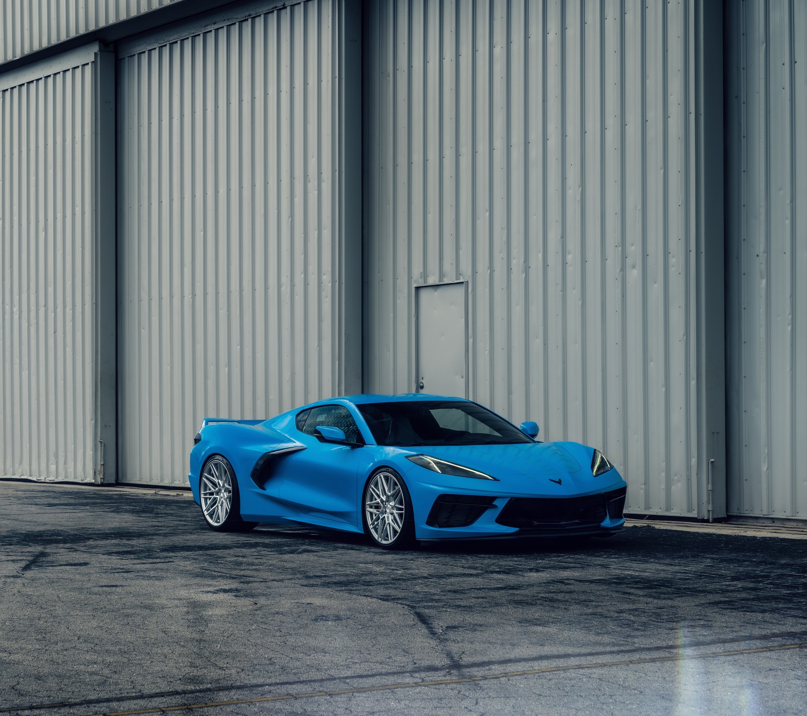 Un primer plano de un coche deportivo azul estacionado frente a un edificio (chevrolet corvette c8, coches deportivos, 5k, coches, fondo de pantalla 4k)