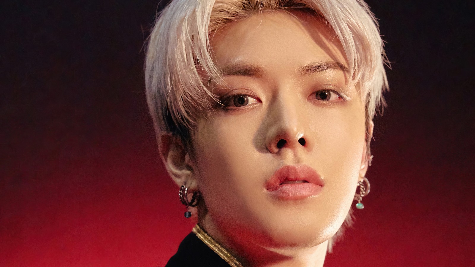 Uma imagem árabe de um homem com cabelo branco e uma jaqueta preta (nct 127, 엔씨티 127, kpop, k pop, soco)