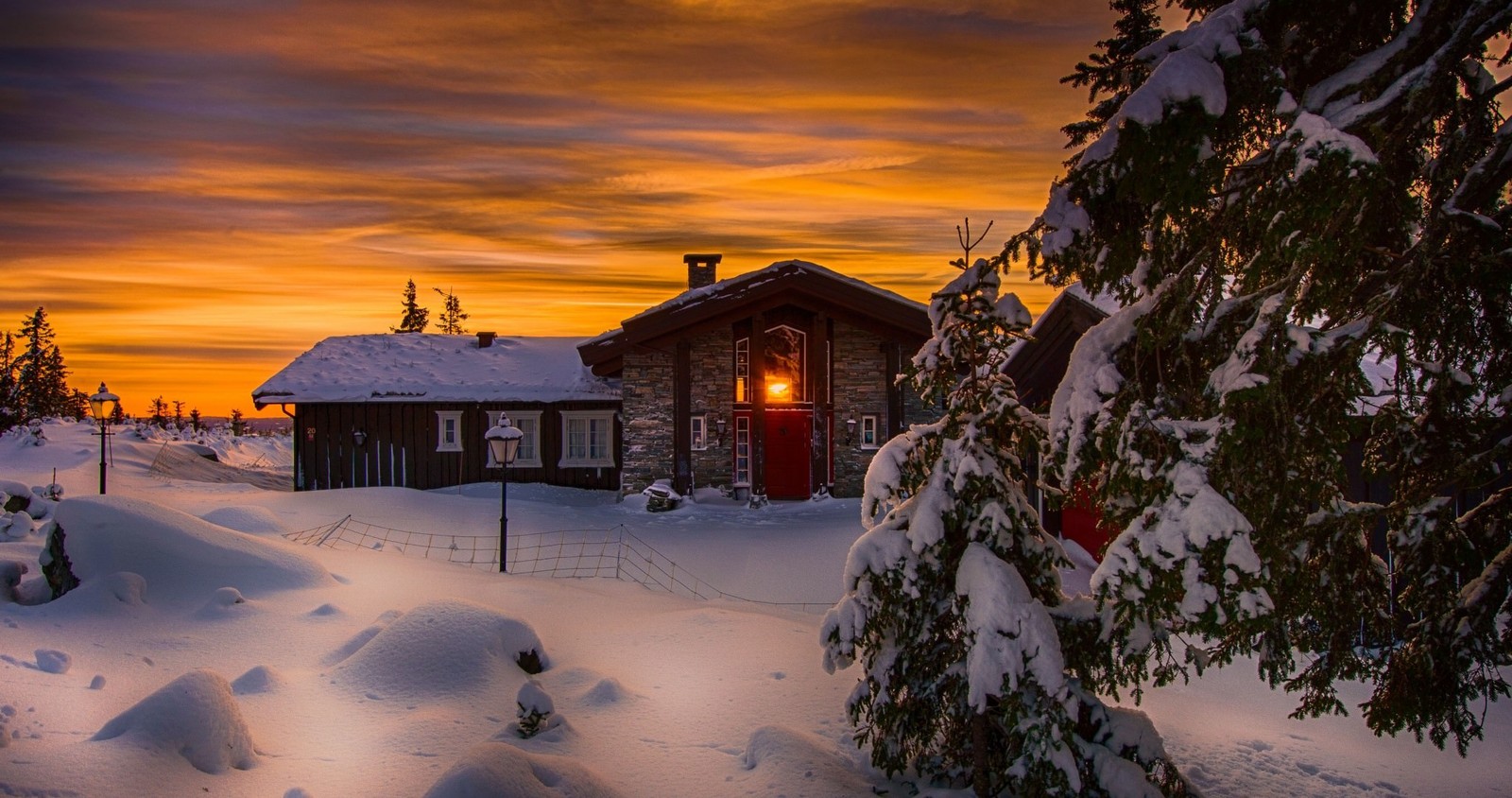 Eine verschwommene hütte im schnee mit einer roten tür (winter, schnee, haus, sonnenuntergang, zuhause)