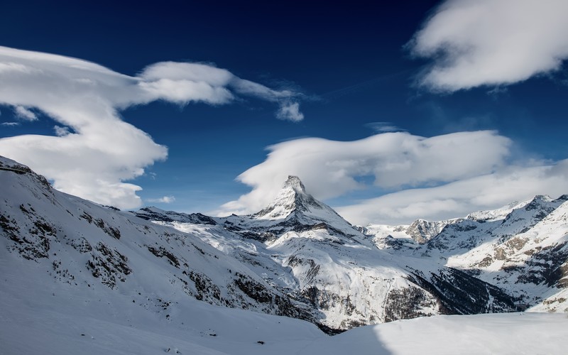 Горы, покрытые снегом и облаками, с человеком на лыжах (маттерхорн, matterhorn, вершина горы, pennine alps, швейцария)