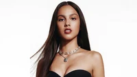 Olivia Rodrigo em um impressionante traje preto com um colar de prata, exalando confiança e elegância.