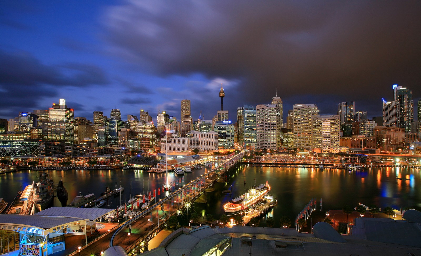 Vista panorámica del horizonte de una ciudad de noche con un barco na água (puente de la bahía de sídney, darling harbour, ópera de sídney, sydney opera house, ciudad)