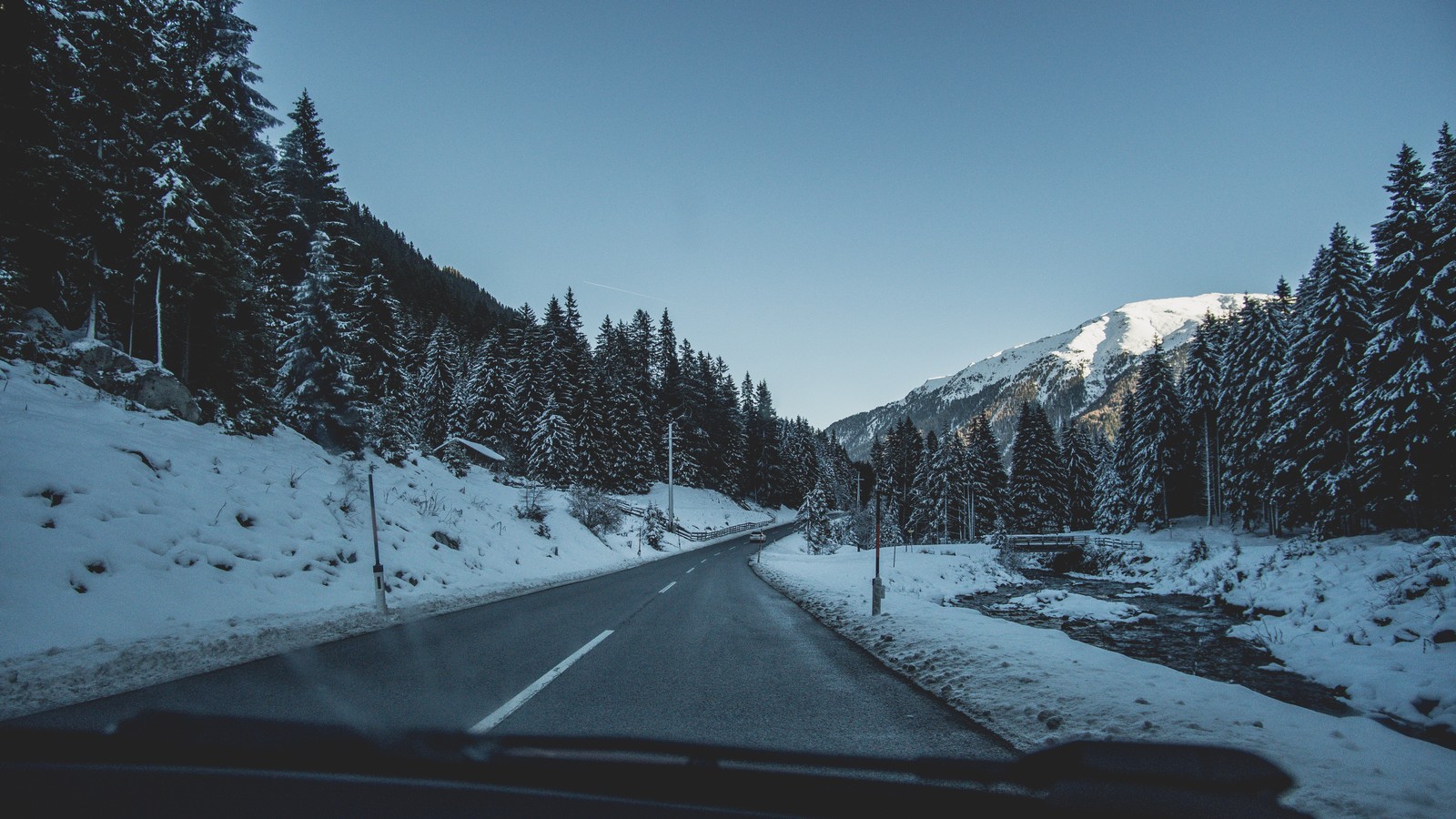 Una vista de una carretera con nieve en el suelo y árboles (nieve, planta, montaña, neumático de automóvil, paisaje natural)