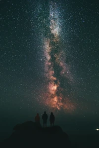 Figuras en silueta mirando la majestuosa Vía Láctea