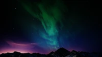 Majestueuse aurore boréale sur une chaîne de montagnes sous un ciel étoilé