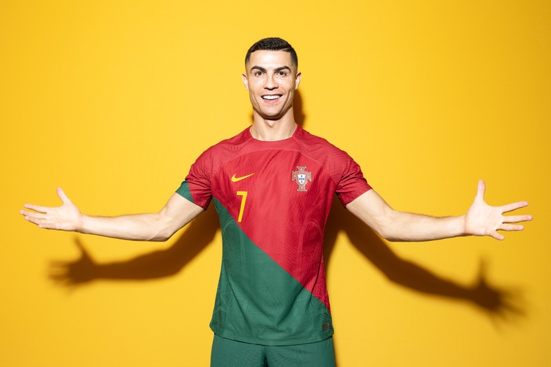 Арафед мужчина в португальской футболке с раскинутыми руками (cristiano ronaldo, желтый фон, футболист из португалии, португальский футболист, спорт)