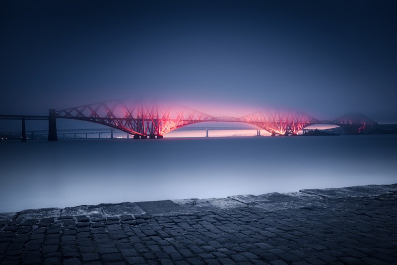 Арабский мост над водоемом с красным огнем (мост форт, forth bridge, великобритания, объект всемирного наследия юнеско, queensferry)