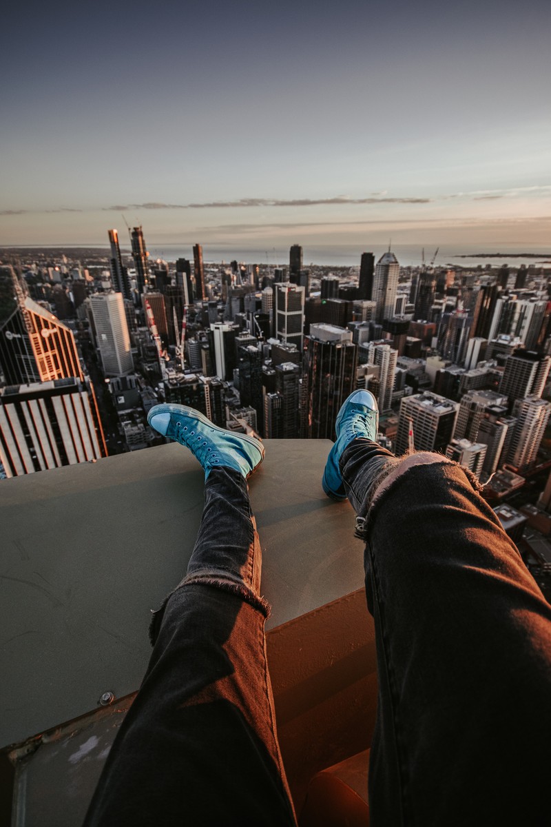 Вид человека, сидящего на уступе с видом на город (башня уиллис, willis tower, тренер, обувь, облако)