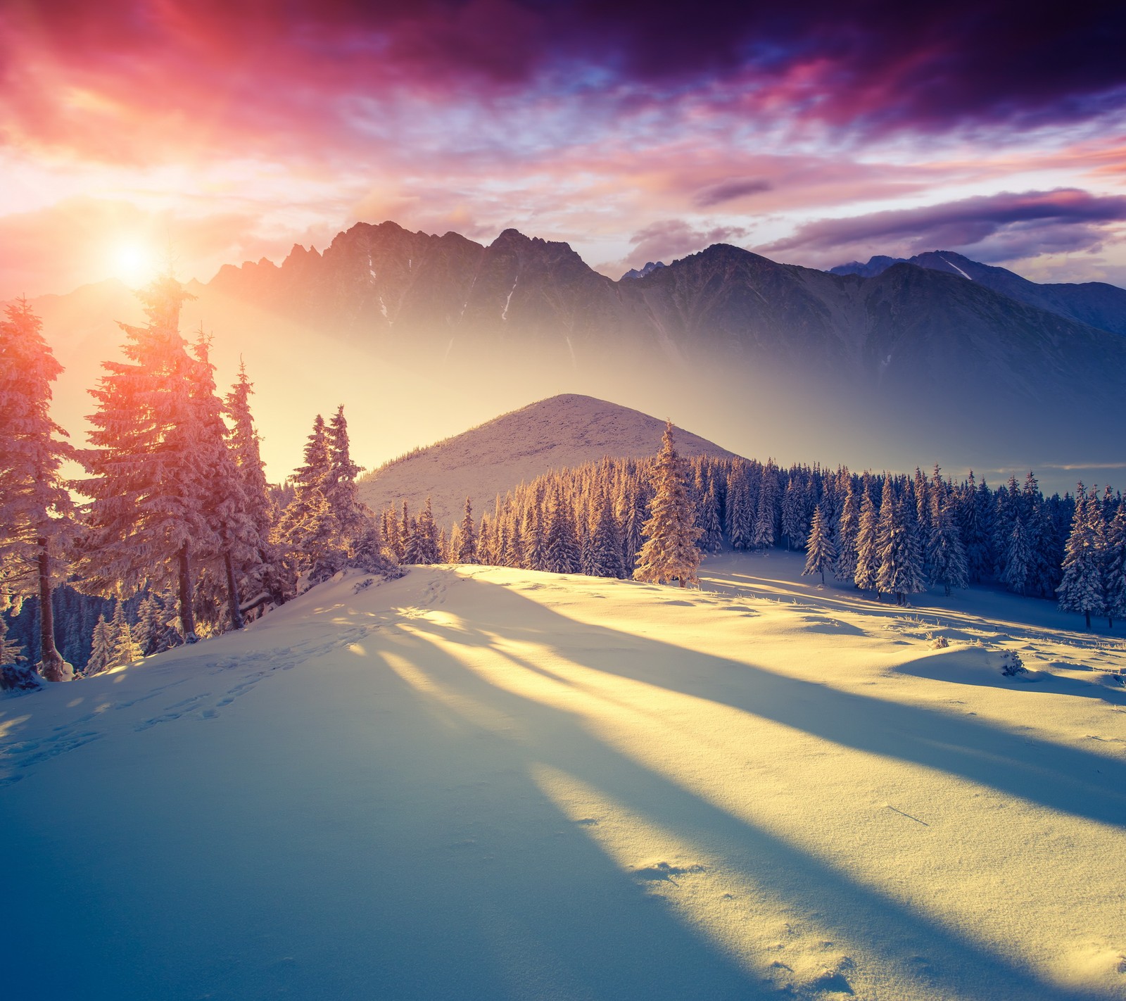 A view of a snowy mountain with a sun setting in the background (landscape, mountains, nature, snow, sunset)