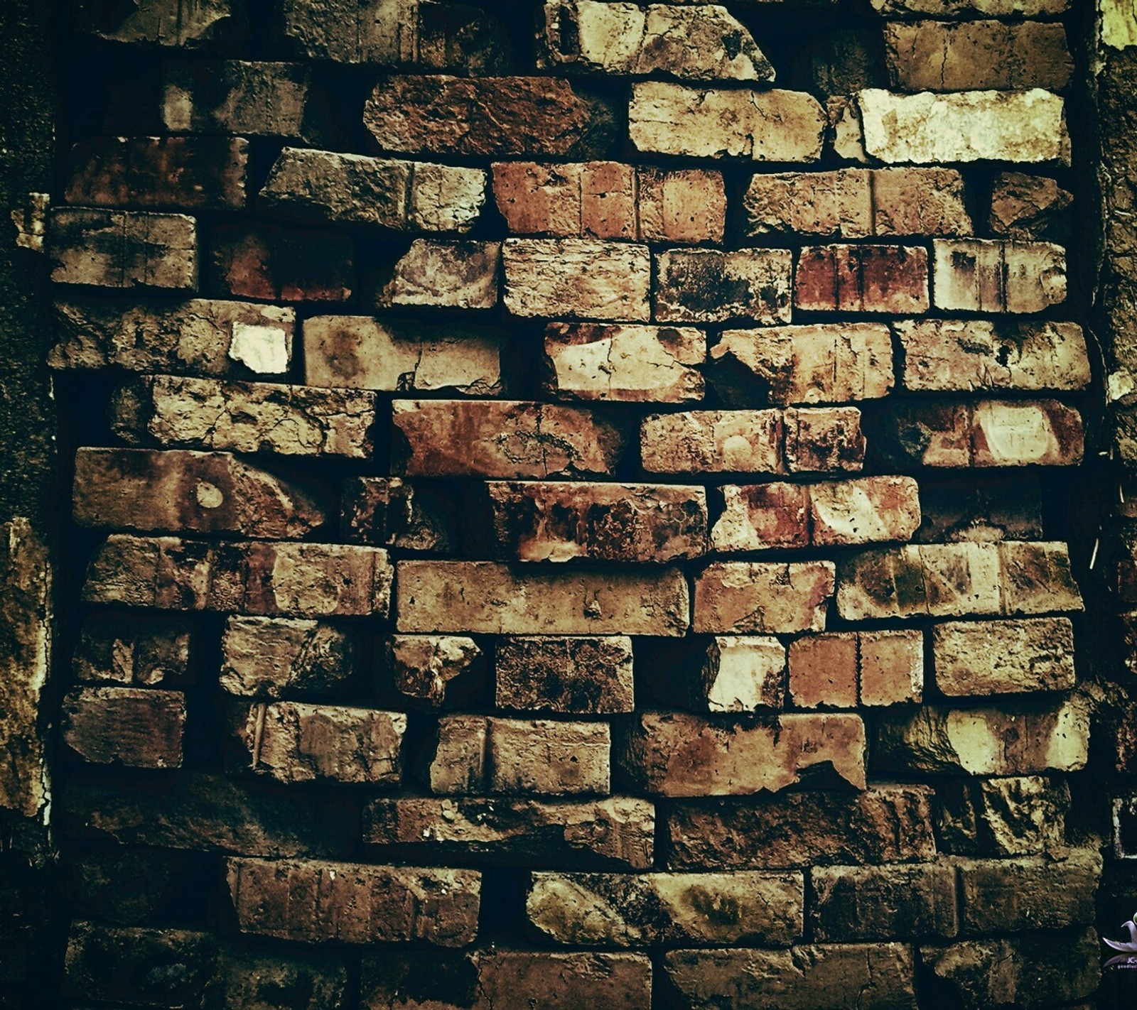 Un primer plano de una pared de ladrillo con un reloj en ella (ladrillos, pared)