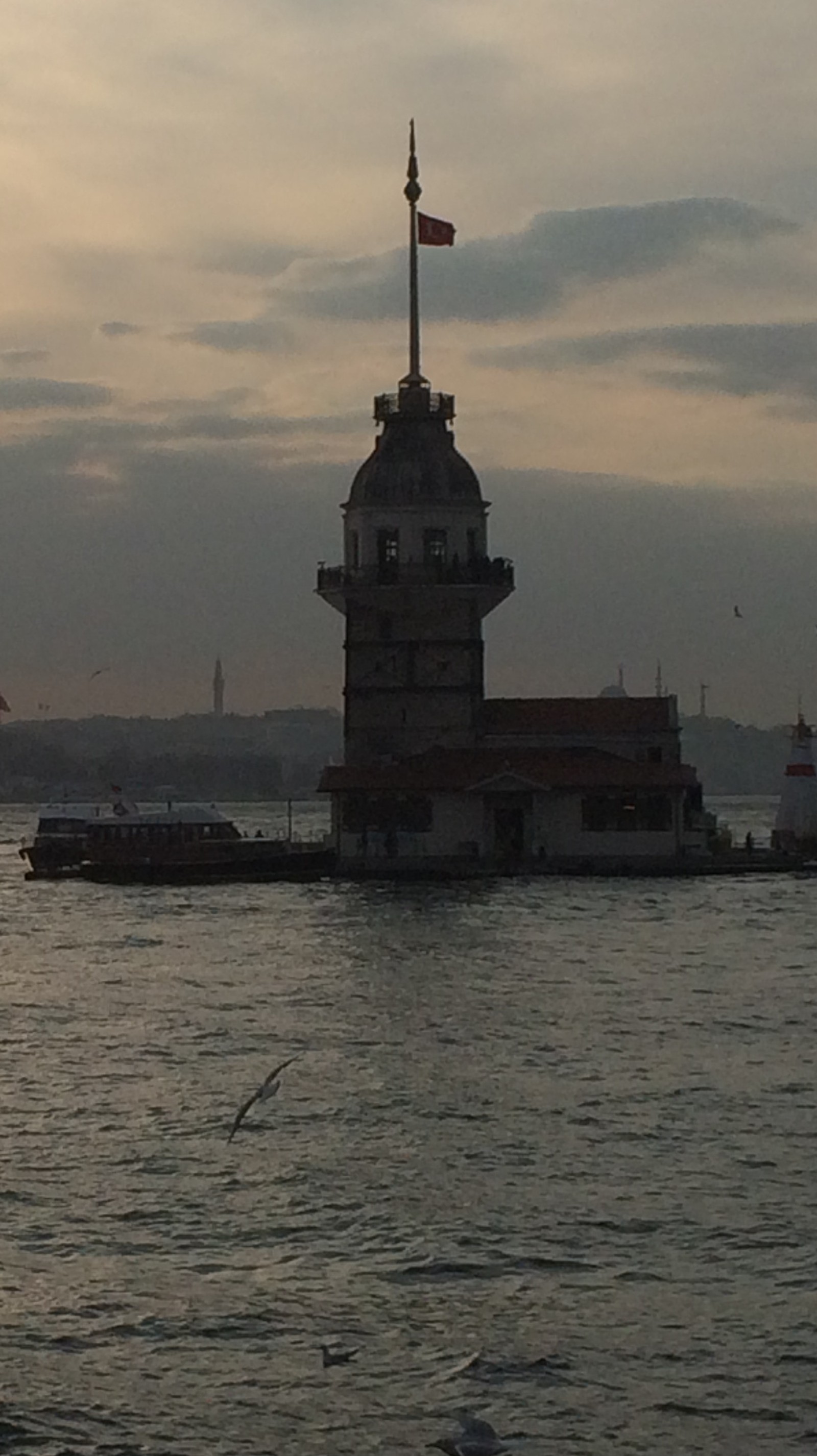 Vue floue d'un phare avec un drapeau sur le dessus (istanbul, tour de la fille, manzara)