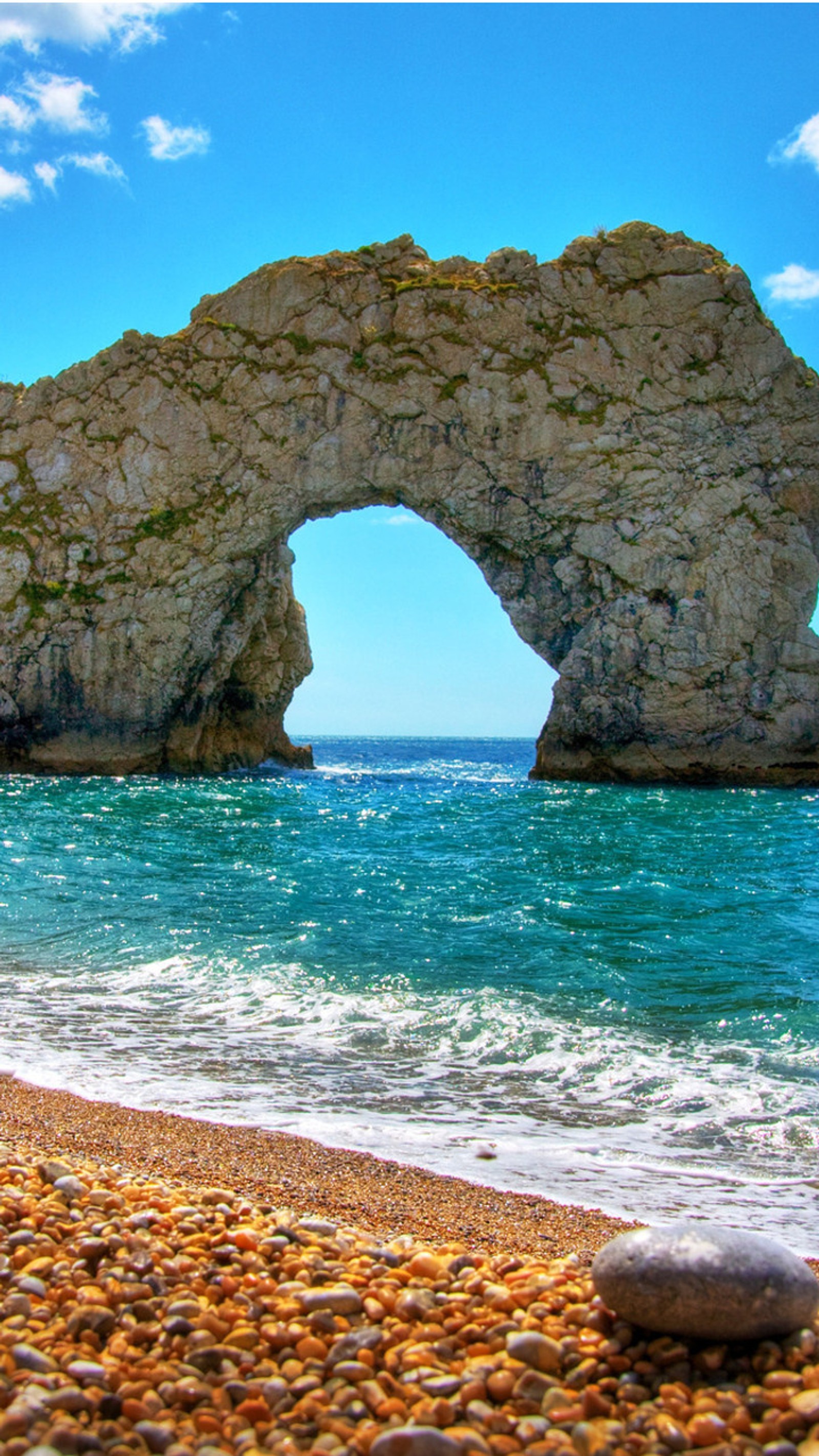 There is a large rock formation on the beach near the water (agua, beach, landscape, nature, onda)