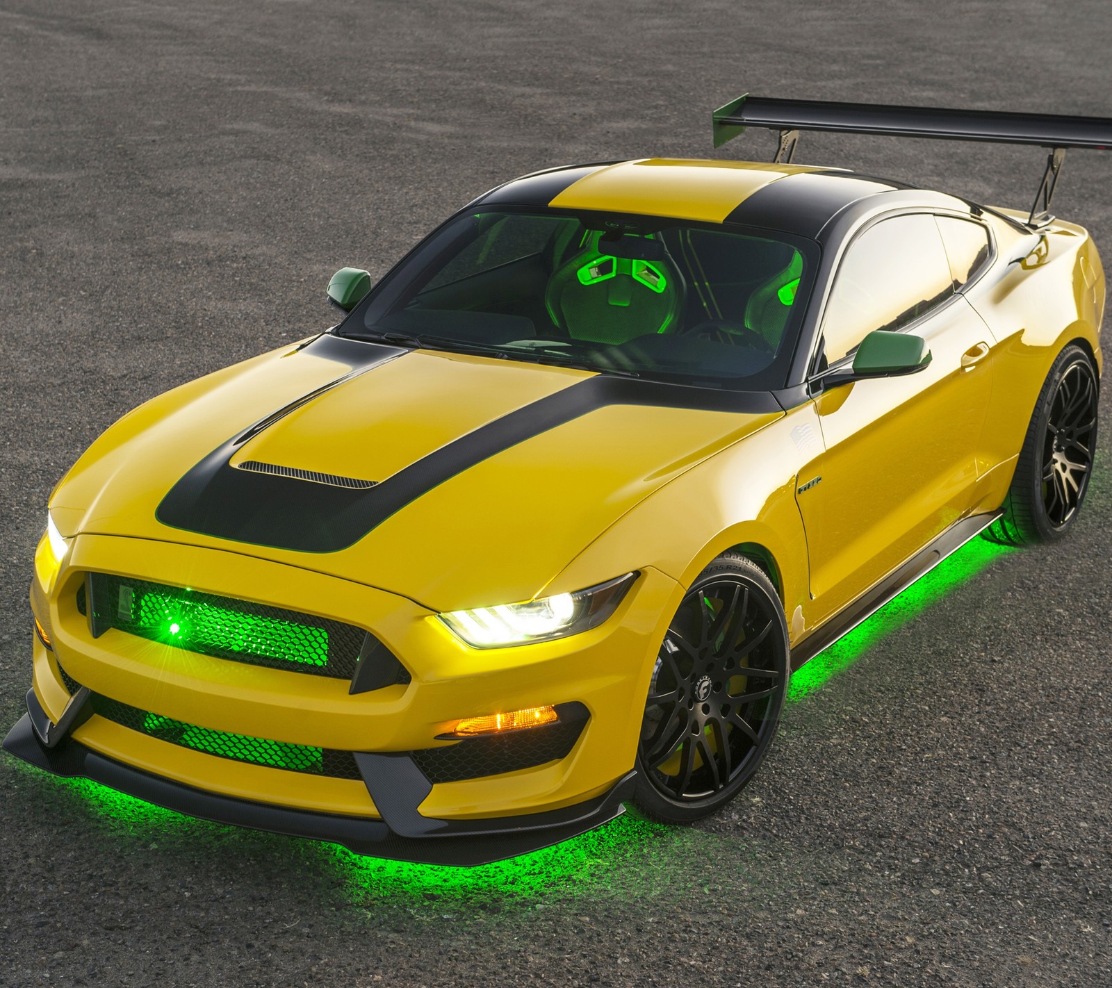 A close up of a yellow mustang with green lights on (auto, car, ford, mustang, stang)