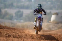 Wheelie de moto tout terrain en action sur une piste de terre