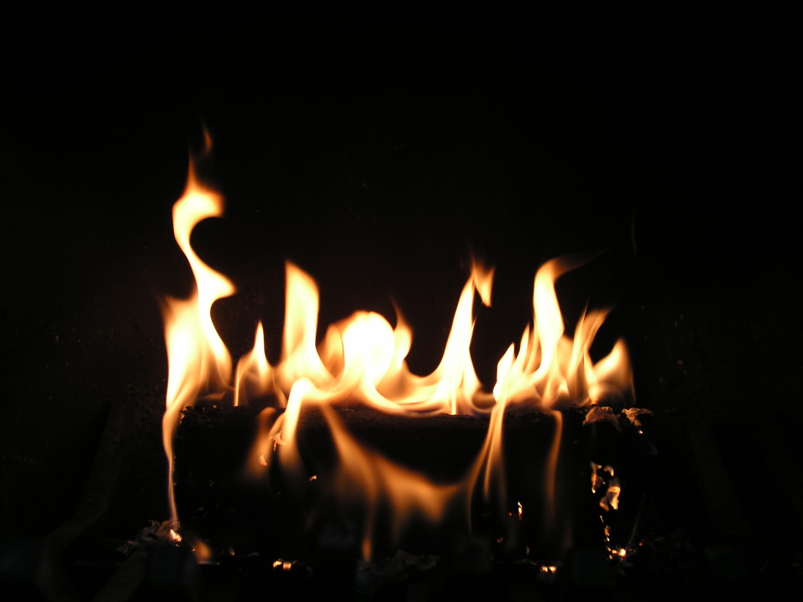 Chamas acesas em uma sala escura com fundo preto (chama, calor, fogo, fogueira, iluminação)