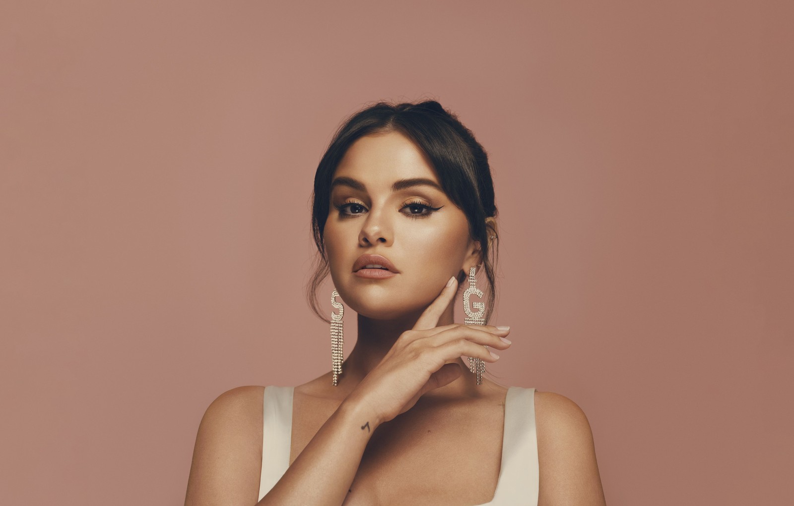 Женщина в белом платье позирует для фотографии (селена гомес, selena gomez, персиковый фон, ювелирные изделия, 5k)