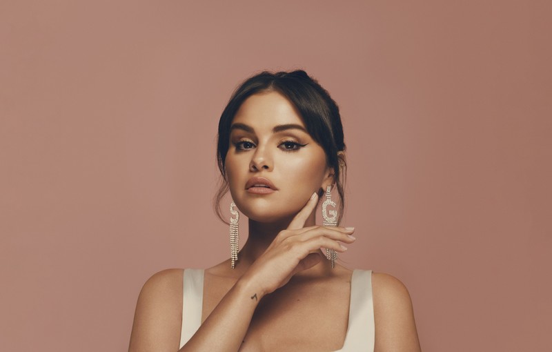 Женщина в белом платье позирует для фотографии (селена гомес, selena gomez, персиковый фон, ювелирные изделия, 5k)