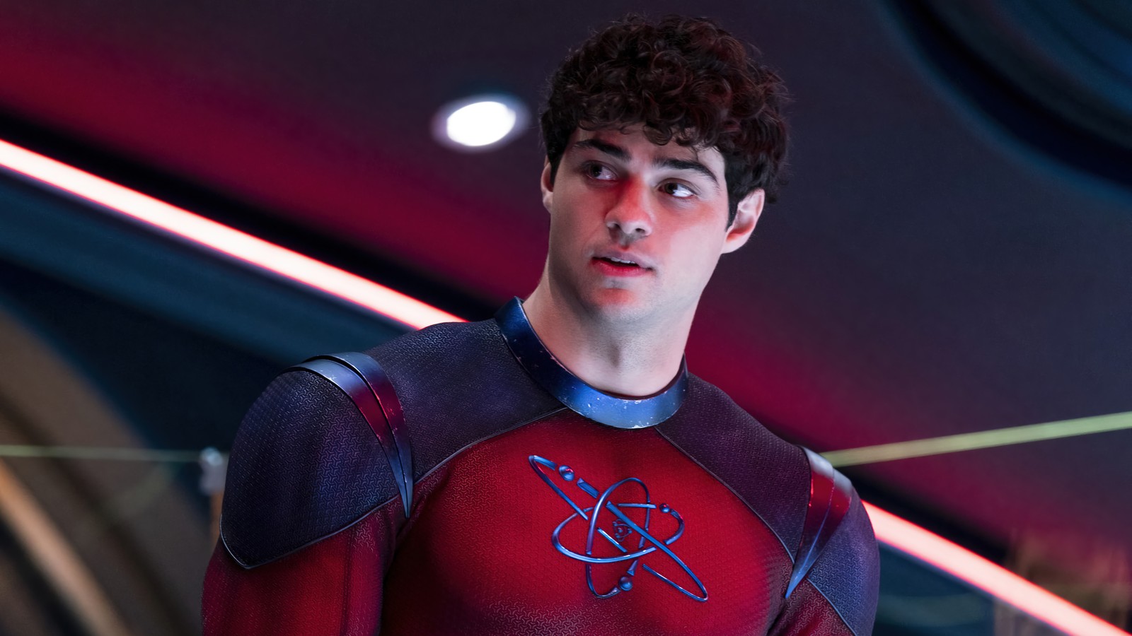 Una toma cercana de un hombre con un traje rojo y azul (destructor de átomos, noah centineo, black adam 2022, película)