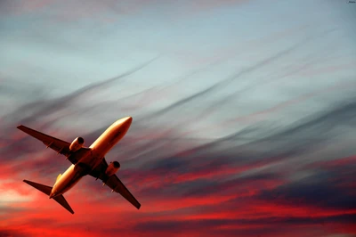 Avión en vuelo contra un cielo de atardecer dramático