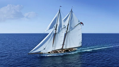 Elegant sailing yacht gliding through Caribbean waters under a clear blue sky.