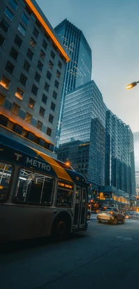 Rascacielos urbanos iluminados al anochecer con autobús del metro y tráfico