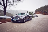 2015 BMW i8: Um elegante carro esportivo navegando por uma estrada montanhosa sinuosa.