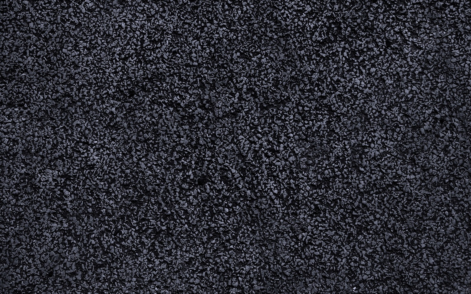 A close up of a black carpet with a lot of small dots (asphalt, black, pattern, granite, tar)