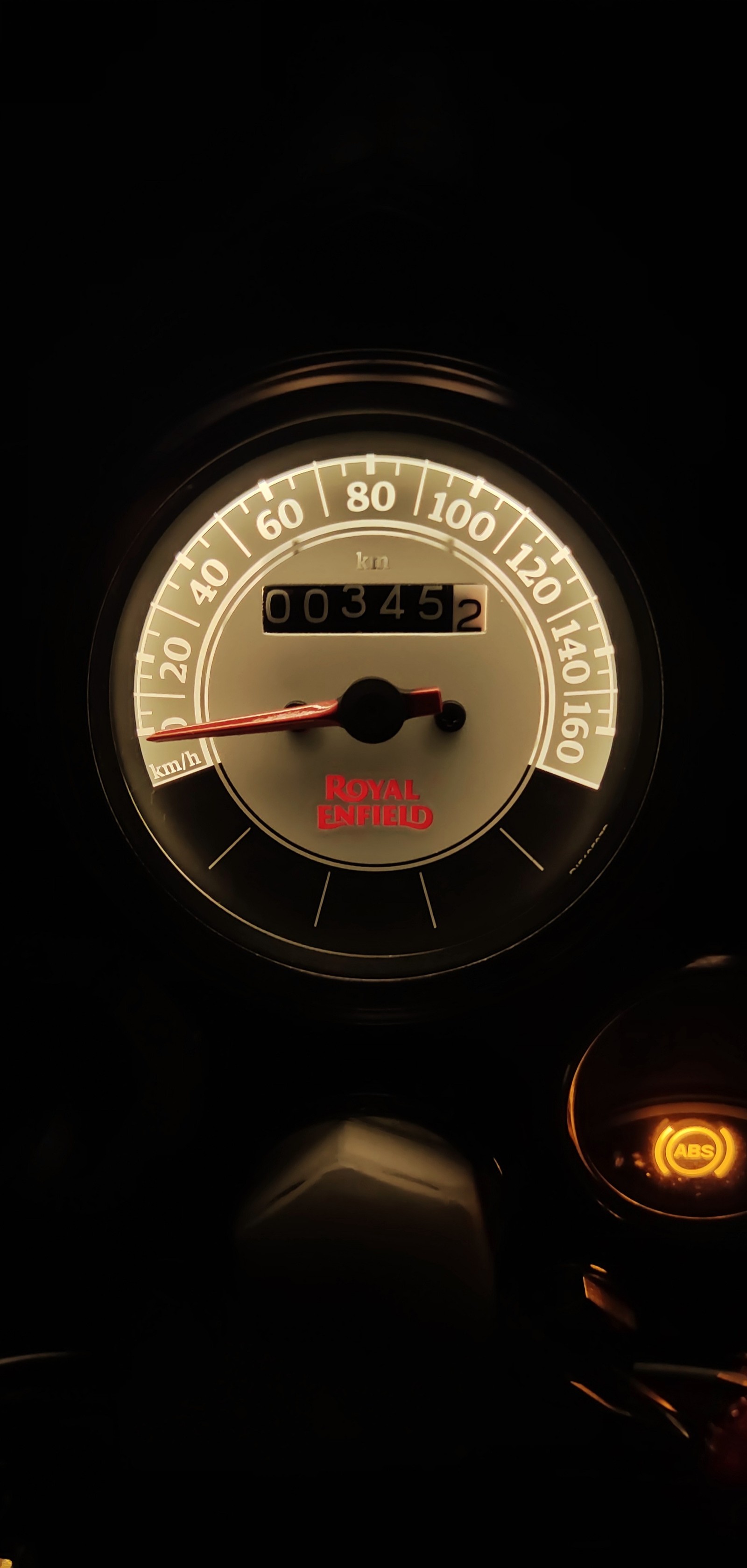 There is a speedometer with a red arrow on it (amoled, bike meter, bs vi, bullet, royal enfield)